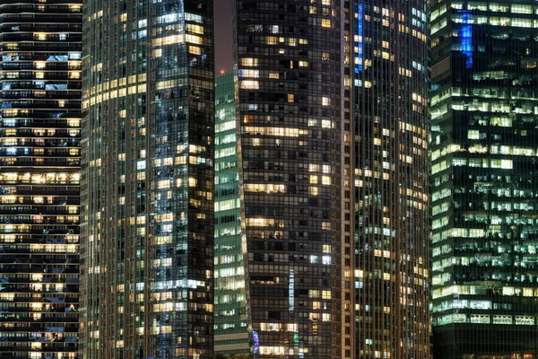 Verbazingwekkende gloeiende ramen van wolkenkrabbers 's avonds — Stockfoto