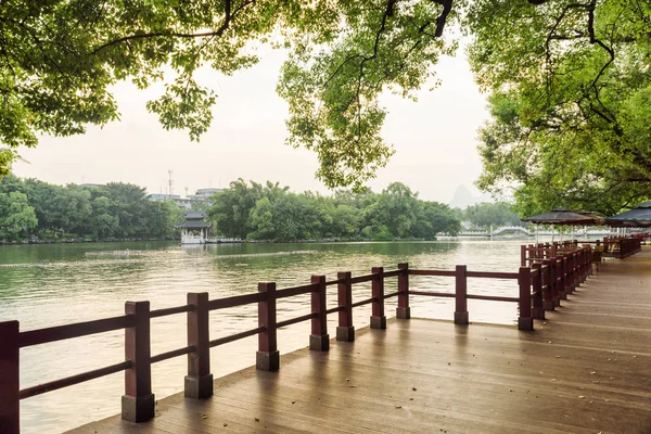 Живописная деревянная дорожка вдоль озера в парке Гуйлинь, Китай — стоковое фото