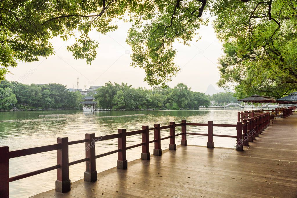 Scenic wooden walkway along lake in park of Guilin, China