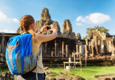 Kadın turist Bayon smartphone ile. Angkor Thom, Cambodia