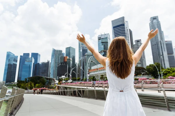 Młoda kobieta z podniesionymi rękami, w centrum miasta Singapur — Zdjęcie stockowe