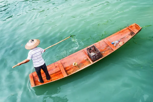 Top view of Asian boatman catching trash from river — Stock Photo, Image