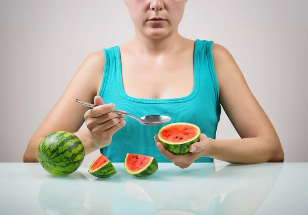 Girl using spoon for eating fresh juicy red small watermelons — Stock Photo, Image