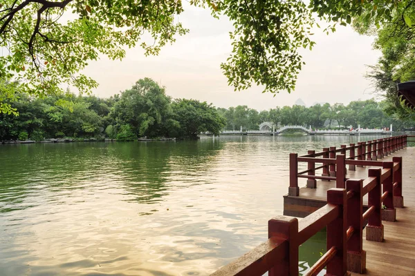 Vista noturna da passarela de madeira ao longo do lago no parque, Guilin — Fotografia de Stock