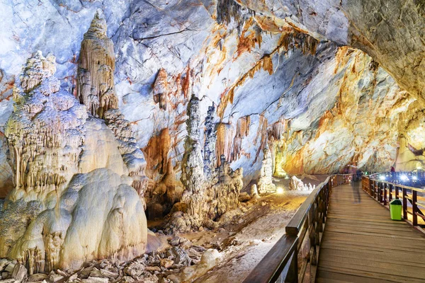 Wooden walkway through natural corridor among stalagmites — Stock Photo, Image