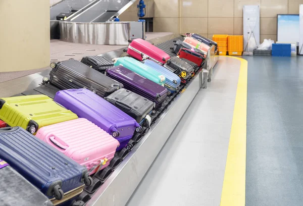 공항 수하물 컨베이어 벨트에 있는 다채 로운 옷 가방 — 스톡 사진