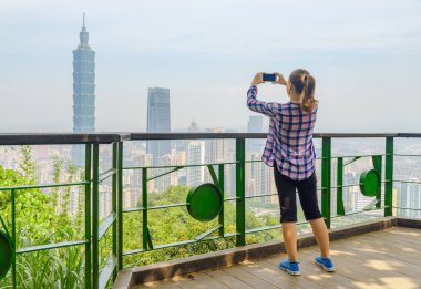 Taipei, Tayvan 'da fotoğraf çeken genç bir bayan turist.