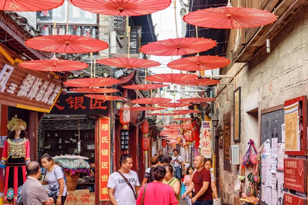 Konforlu cadde geleneksel Çin kırmızı şemsiyeleriyle süslenmiş. — Stok fotoğraf