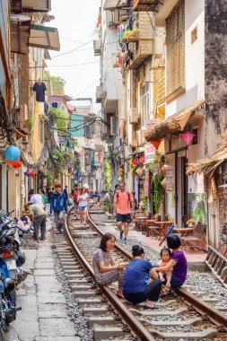 Viyetnam 'daki Hanoi Tren Caddesi' nde demiryolunda dinlenen vatandaşlar.