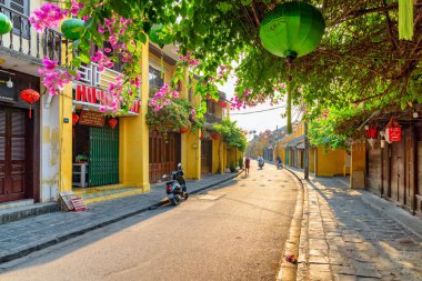 Hoi An (Hoian), Vietnam - April 12, 2018: Gorgeous morning view of cozy street decorated with colorful silk lanterns. Scenic traditional old yellow houses of Hoi An Ancient Town.