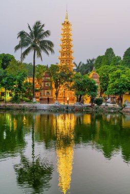 Hanoi, Vietnam - April 19, 2019: Beautiful evening view of the Tran Quoc Pagoda and West Lake. The pagoda reflected in water. The Buddhist temple is a popular destination among tourists and pilgrims.