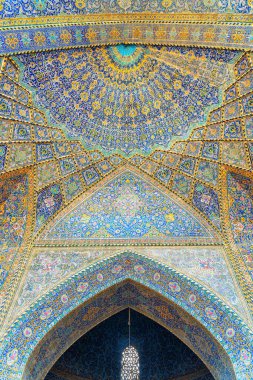 Isfahan, Iran - 24 October, 2018: Gorgeous view of ceiling and walls covered with colorful mosaic and calligraphic inscriptions in Seyyed Mosque. Amazing Persian interior. Islamic architecture.