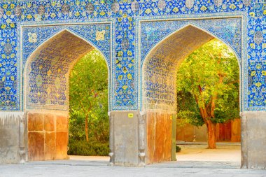 Isfahan, Iran - 23 October, 2018: Awesome arches covered with colorful mosaic tiles at courtyard of the Shah Mosque (Imam Mosque). Amazing Persian exterior of the Muslim place. Islamic architecture.