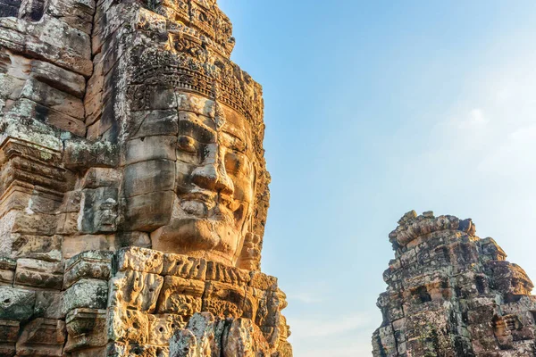 Wonderful view of mysterious giant smiling stone face of ancient Bayon temple at sunset, Angkor Thom, Siem Reap, Cambodia. Angkor Thom is a popular tourist attraction of Asia.