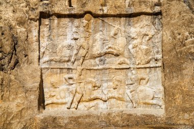 İran 'daki Naqsh-e Rustam antik mezarlığında orjinal bas-tasfiye. Achaemenid krallarına ait büyük bir mezarın ayrıntıları yerden oldukça yüksek bir yükseklikte kaya yüzeyinden oyulmuş..