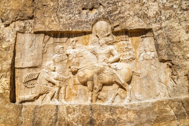 İran 'daki Naqsh-e Rustam antik mezarlığında güzel bir rahatlama. Achaemenid krallarına ait büyük bir mezarın ayrıntıları yerden oldukça yüksek bir yükseklikte kaya yüzeyinden oyulmuş..