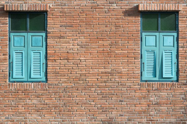 Кирпичная стена с голубыми окнами — стоковое фото