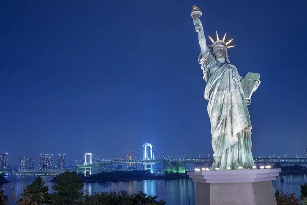 Statue of Liberty and Rainbow bridge at Odaiba Tokyo in twilight Royalty Free Stock Images