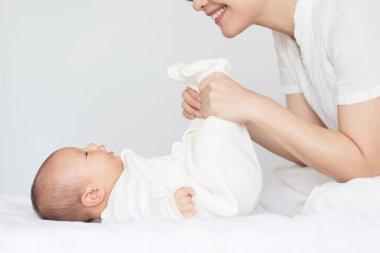 Mutlu bir aile. Anne yatak odasında bebeğiyle oynuyor.