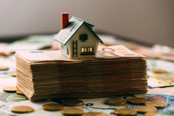 Modelo da casa no fechamento da pilha de dinheiro — Fotografia de Stock