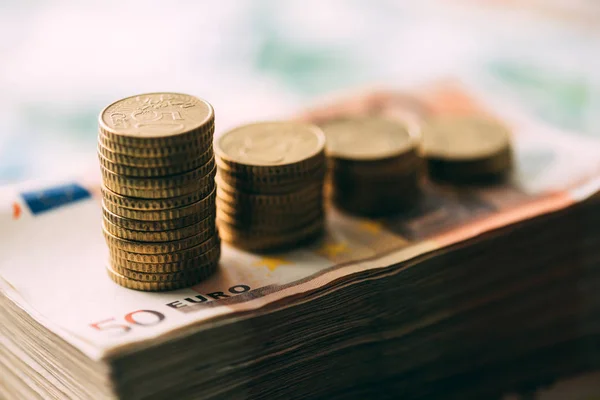 Euro coins on cash stack closeup