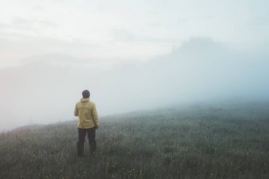 Sarı ceketli yalnız bir turist.