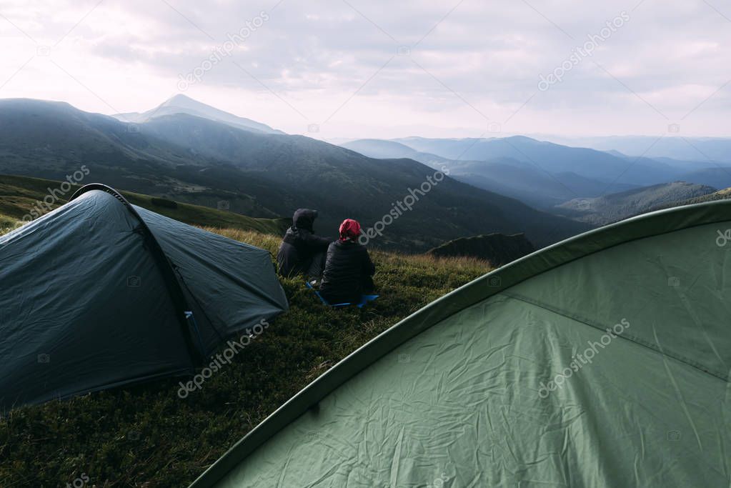 Couple near tent on mountains closeup
