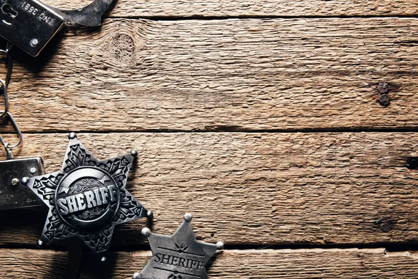 Звезда шерифа и наручники на деревянном столе — стоковое фото