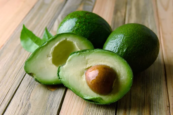 Frische Avocadofrüchte auf einem Holzbrett — Stockfoto