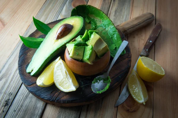 Frutas frescas de abacate numa tábua de madeira — Fotografia de Stock