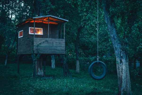 Hus på träd i aftonträdgård — Stockfoto