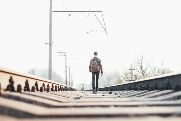 Teenager mit kleinem weißen Hund auf Bahngleisen — Stockfoto