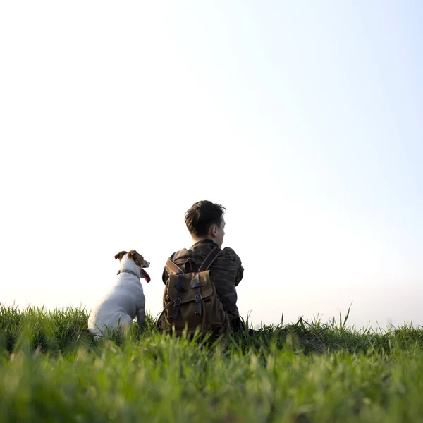 Adolescente en el césped verde con pequeño perro blanco —  Fotos de Stock