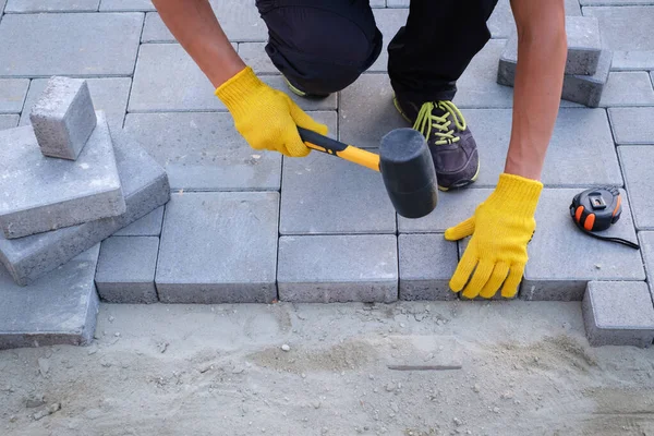 The master in yellow gloves lays paving stones — Stock Photo, Image