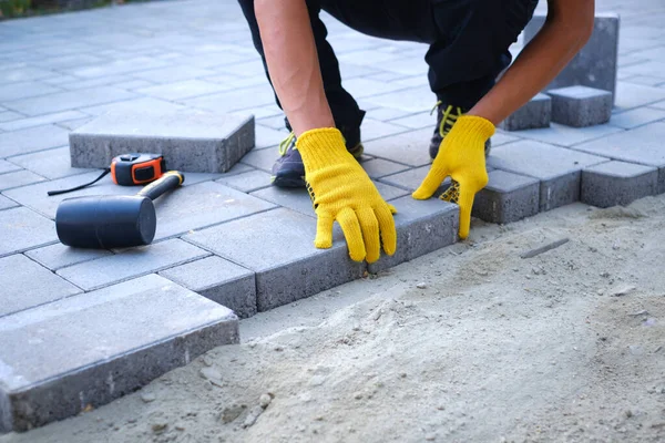 The master in yellow gloves lays paving stones — Stock Image The master in yellow gloves lays paving stones Stock Picture