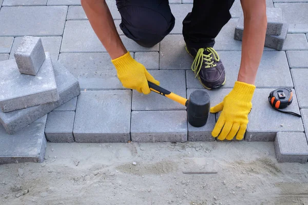 The master in yellow gloves lays paving stones — Stock Photo, Image