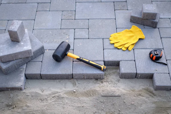 The master in yellow gloves lays paving stones — Stock Photo, Image