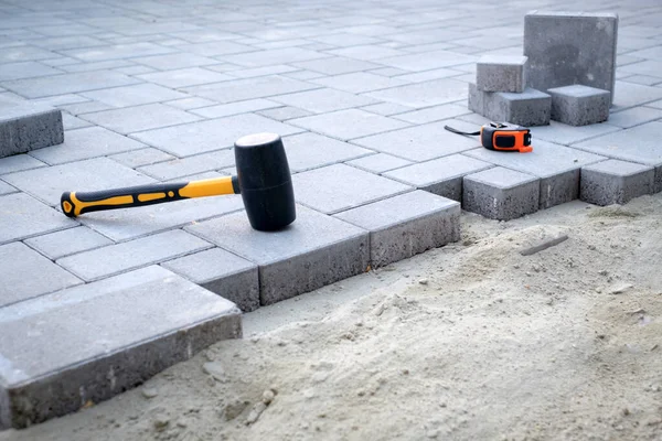 The master in yellow gloves lays paving stones — Stock Photo, Image