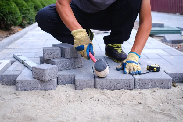 The master in yellow gloves lays paving stones — Stock Image The master in yellow gloves lays paving stones Royalty Free Stock Images