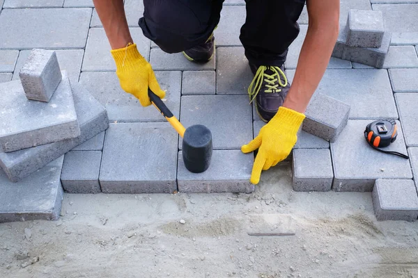 The master in yellow gloves lays paving stones — Stock Image The master in yellow gloves lays paving stones Royalty Free Stock Photos