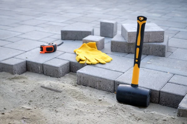 The master in yellow gloves lays paving stones — Stock Image The master in yellow gloves lays paving stones Royalty Free Stock Photos