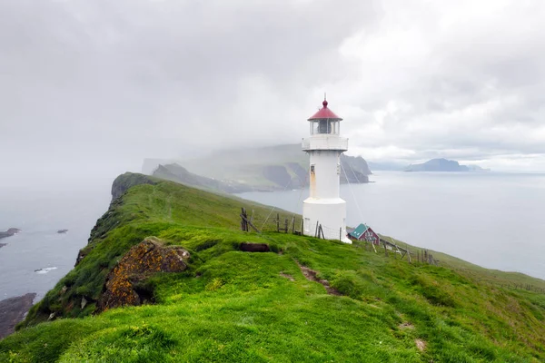 Foggy view of old lighthouse on the Mykines island — Stock Photo, Image