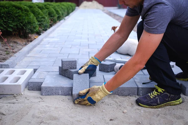 The master in yellow gloves lays paving stones — Stock Image The master in yellow gloves lays paving stones Stock Picture