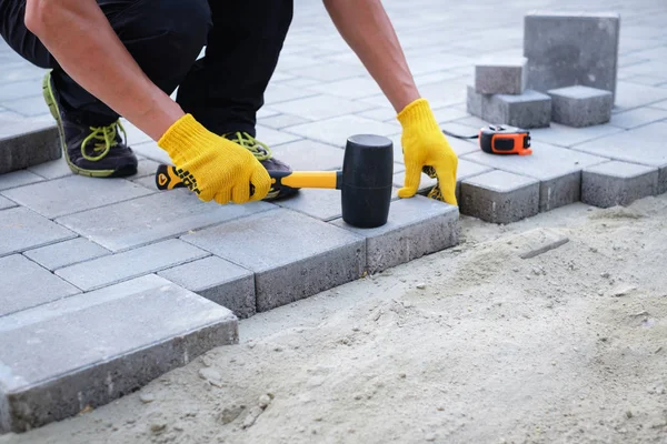 The master in yellow gloves lays paving stones — Stock Image The master in yellow gloves lays paving stones Stock Photo