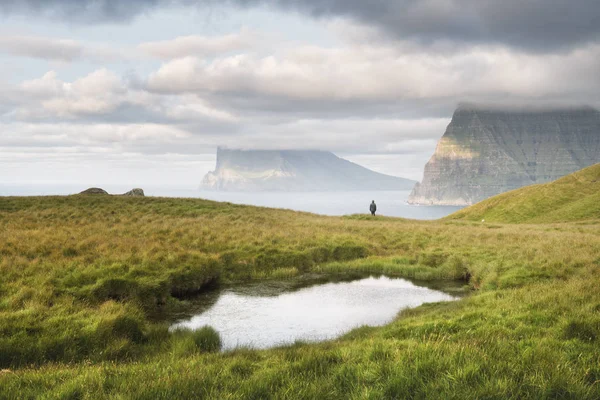 Touriste solitaire près d'un petit lac regarde les îles brumeuses dans l'océan Atlantique — Photo