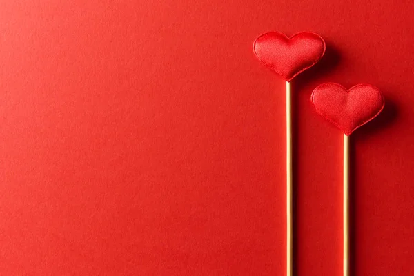 Красные текстильные сердца на деревянных палочках крупным планом — стоковое фото