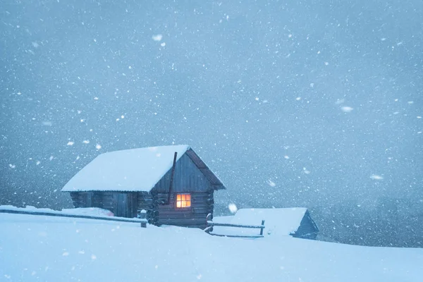 Fantastic landscape with snowy house in snowstorm — Stockfoto