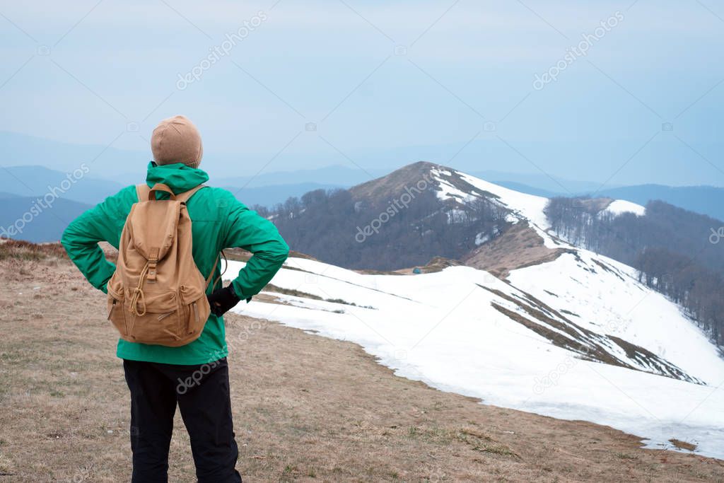 Tourist with backpack in snowy mountains