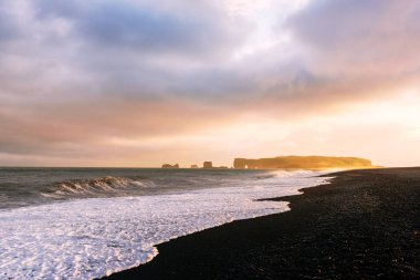İnanılmaz gün batımı ışığı ve kara sahilde büyük dalgalar.