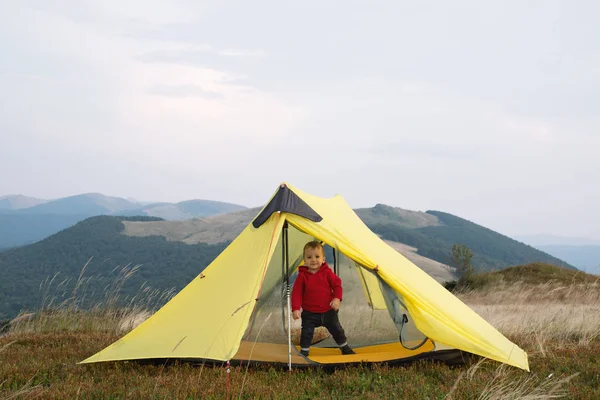 Bambino piccolo in tenda gialla in montagna primaverile — Foto Stock